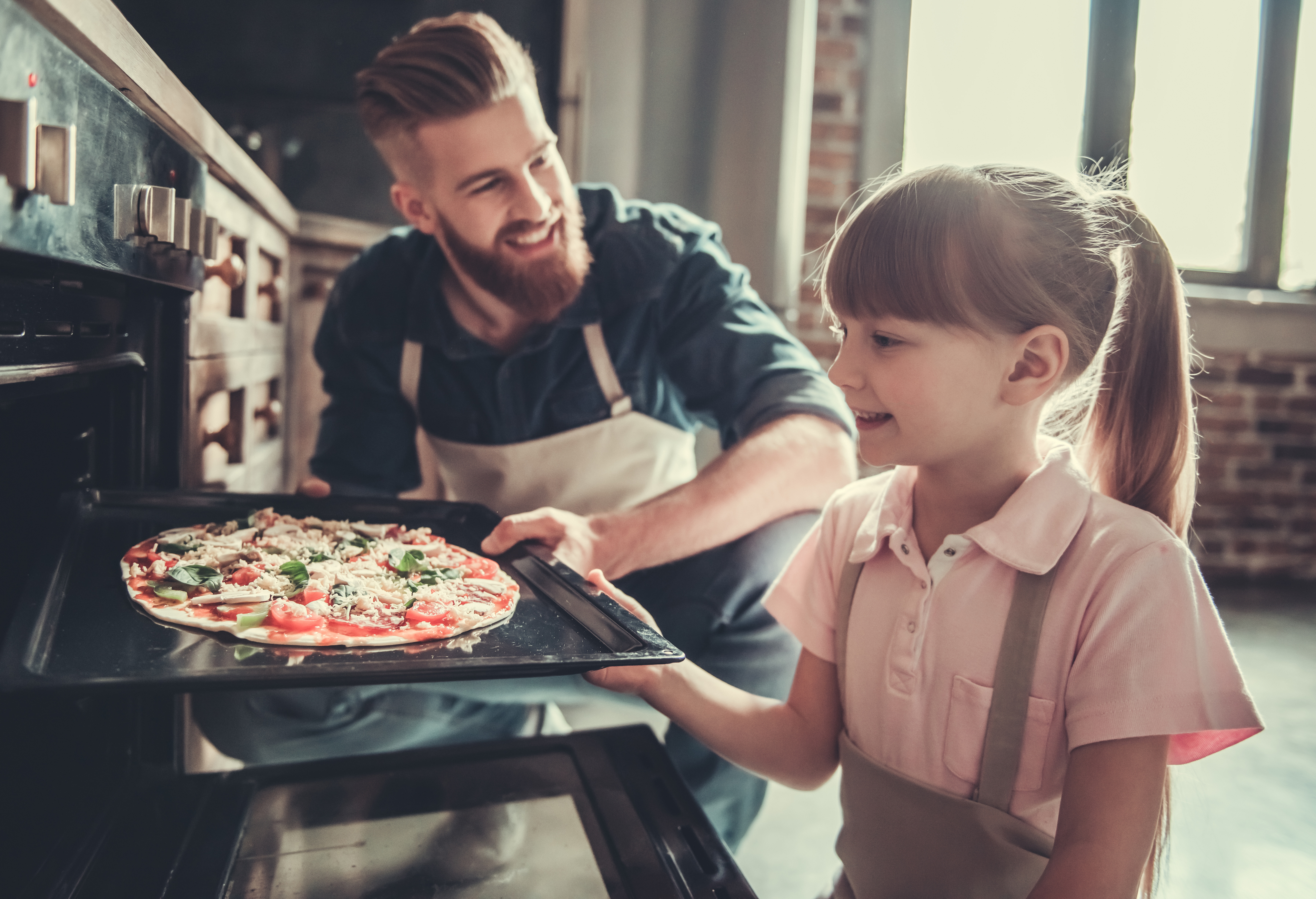 Kleines Mädchen backt Pizza mit Ihrem Vater