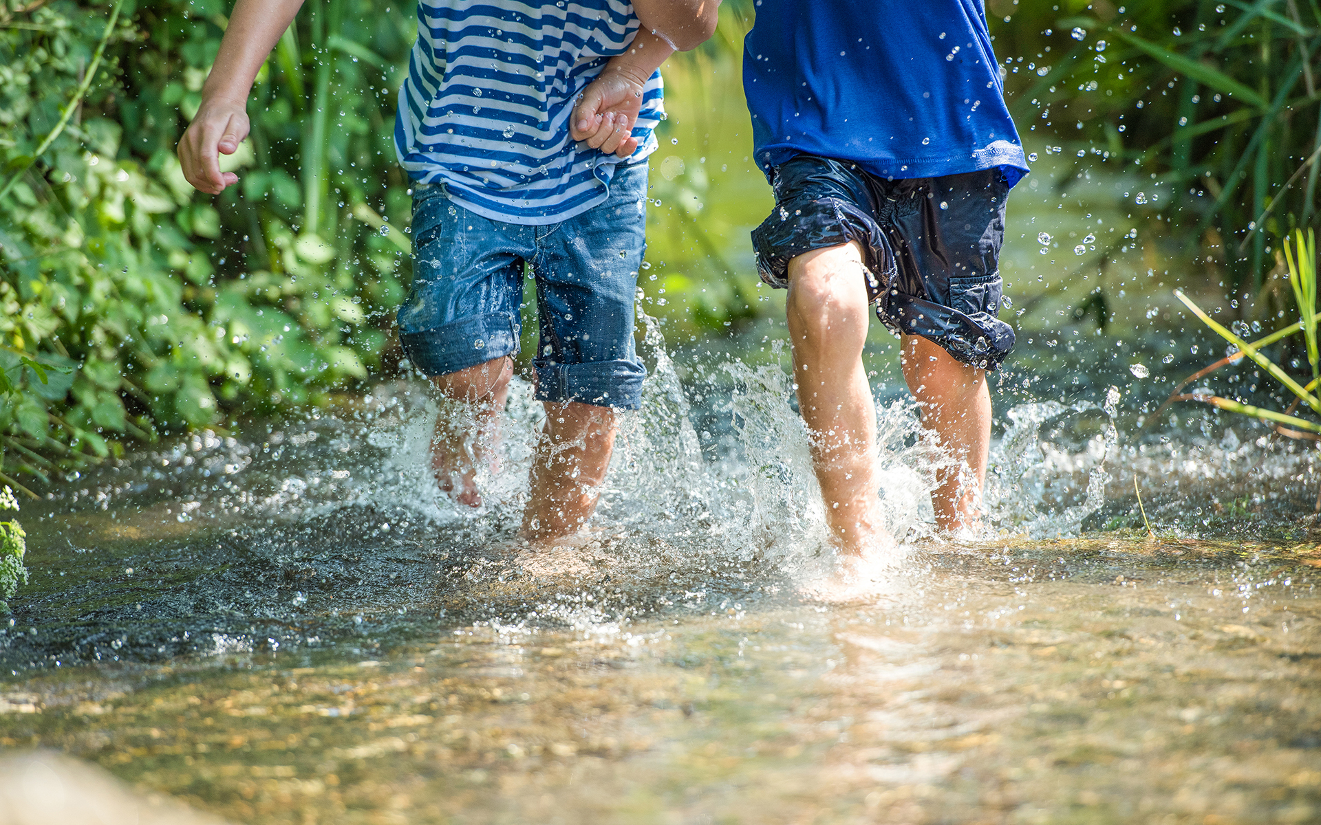 Jungs rennen durch klares Wasser