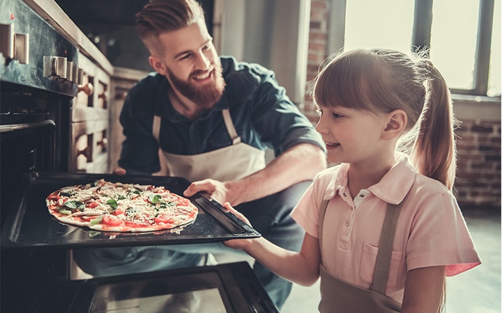 Vater und Tochter beim Pizzabacken