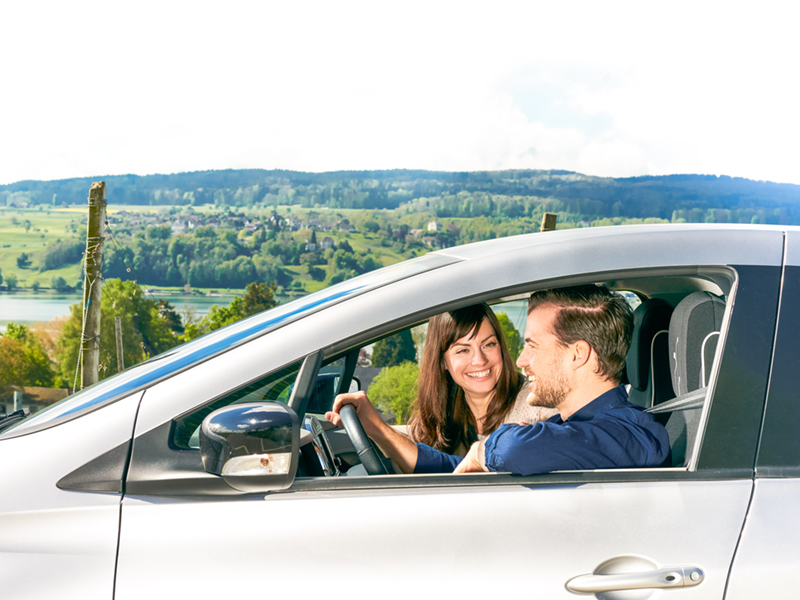 Paar im elektrischen Auto bei Überlandsfahrt